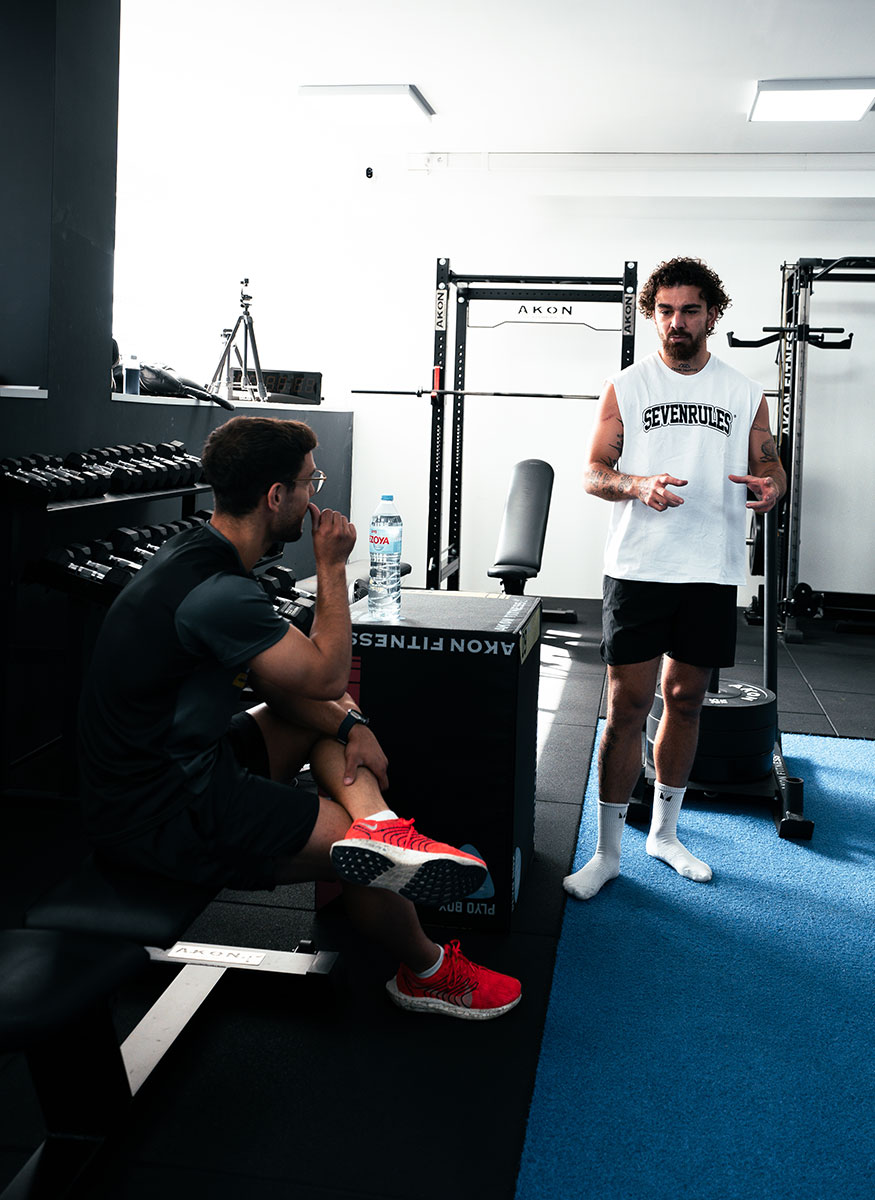 Entrenadores discutiendo algo en el gimnasio.